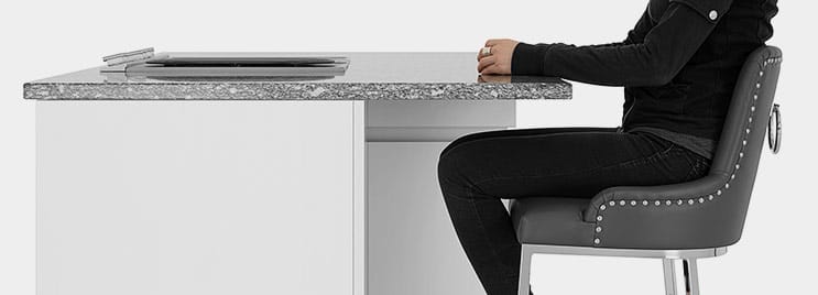 Photograph Showing A Person Sat On A Kitchen Stool At A Kitchen Island